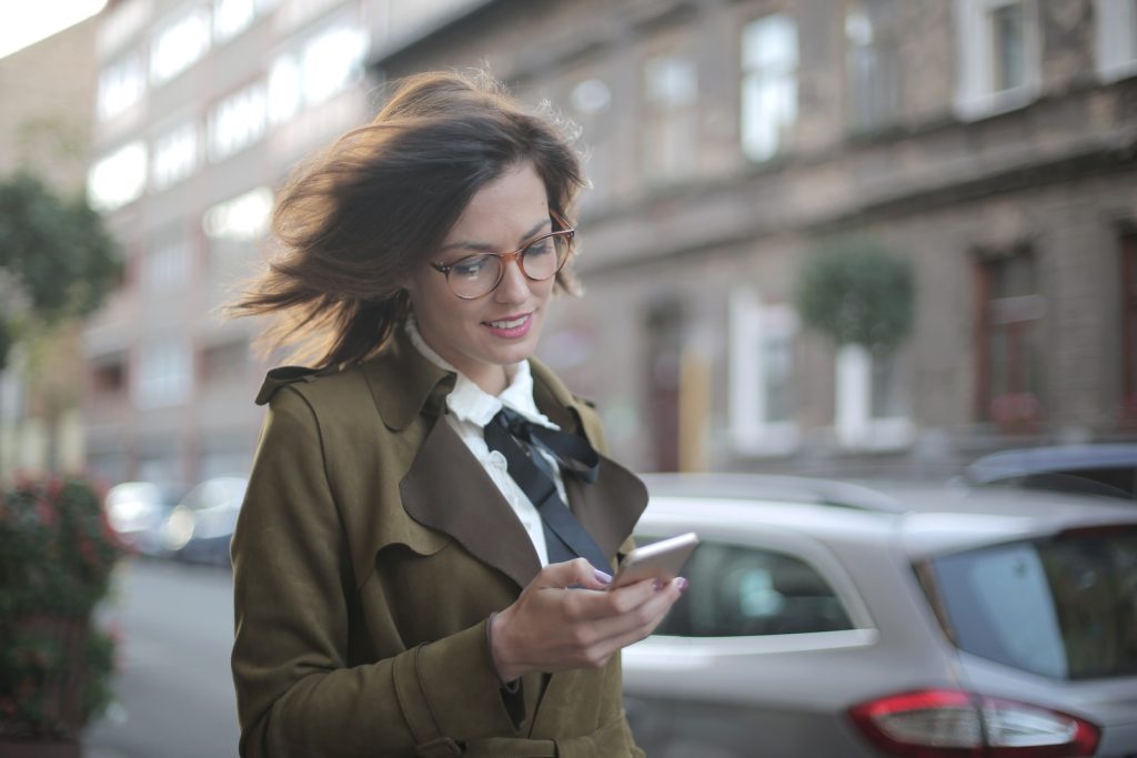 The Ultimate Viggle App Review: Earn Money Watching TV or a Time-Wasting Scam? 2 Stylish adult female using smartphone on street