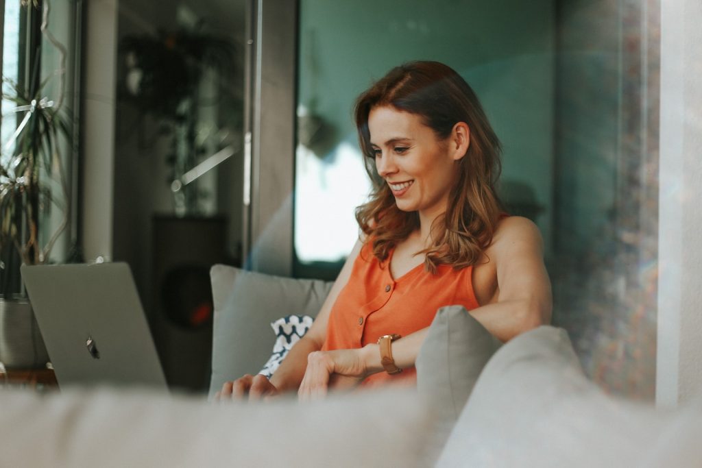 Apple At Home Advisor Review woman in orange sleeveless top sitting on couch