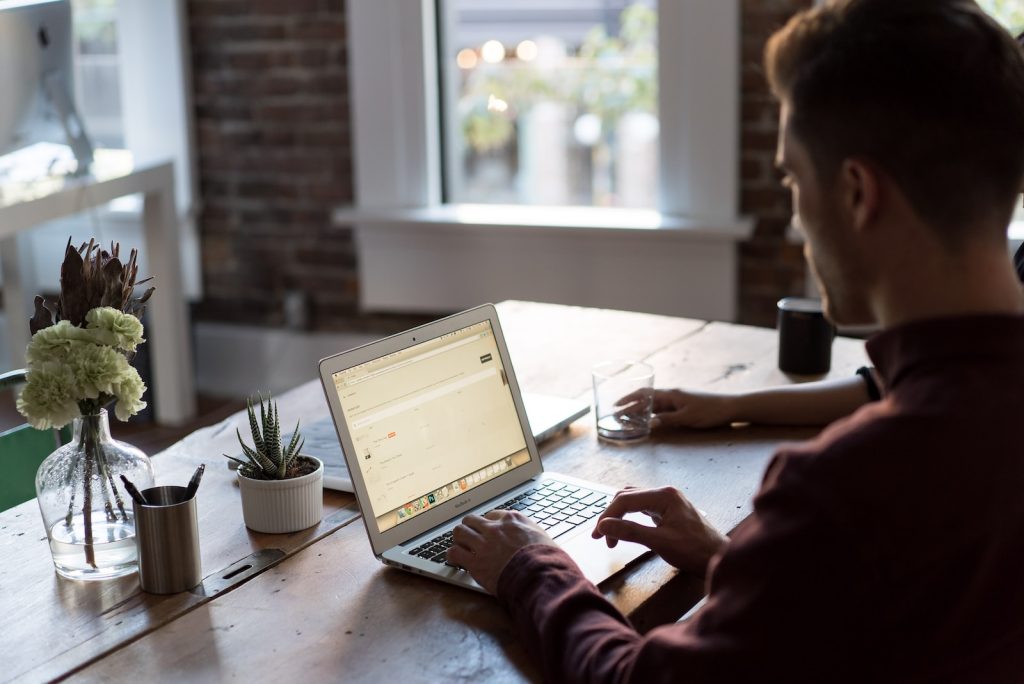 Scribie Review man operating laptop on top of table