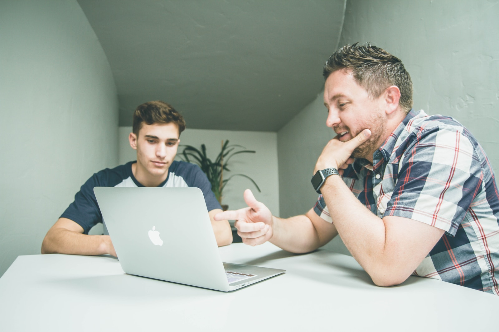 Remotasks Review 2024: Is it Legit or a Scam? 5 man wearing white and black plaid button-up sports shirt pointing the silver MacBook