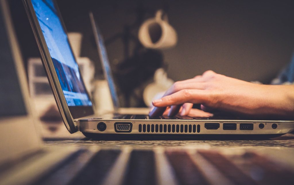 Online Reputation Management Services person using silver laptop computer on desk