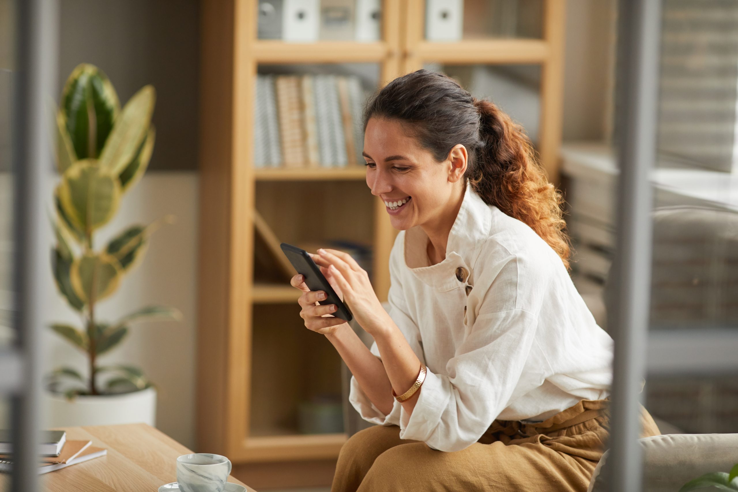 Smiling Businesswoman Looking at Smartphone Screen